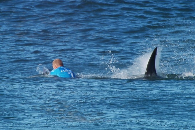 In this image made available by the World Surf League, Australian surfer Mick Flanning is pursued by a shark, in Jeffrey's Bay, South Africa, Sunday, July 19, 2015. (World Surf League via AP)